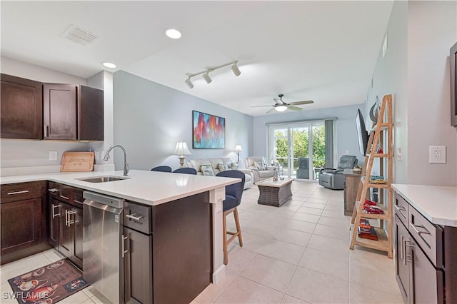 kitchen with a sink, visible vents, a kitchen breakfast bar, open floor plan, and dishwasher