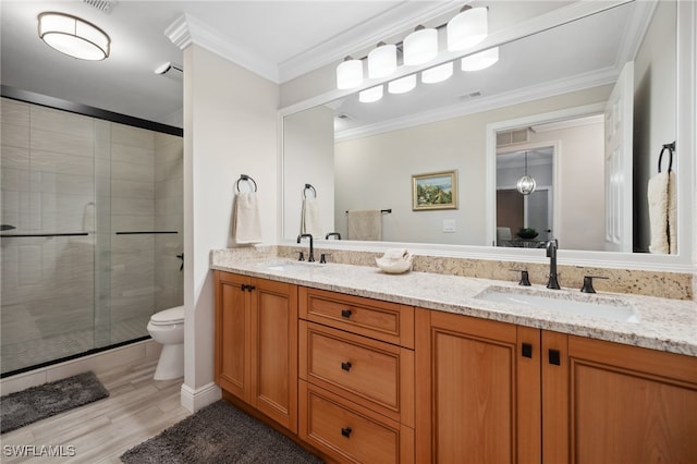 bathroom featuring double vanity, a stall shower, a sink, and crown molding