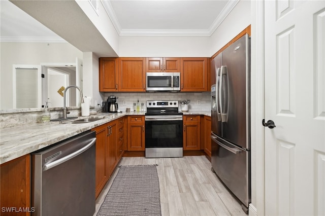 kitchen featuring appliances with stainless steel finishes, a sink, light stone counters, and tasteful backsplash