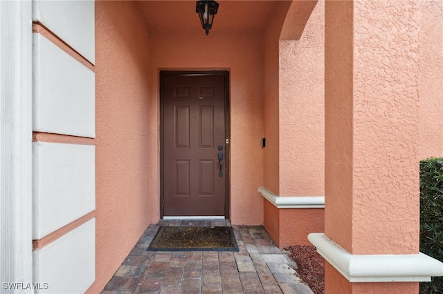 entrance to property featuring stucco siding