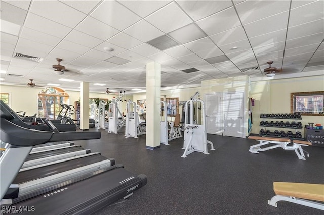 gym featuring a ceiling fan, a paneled ceiling, and visible vents