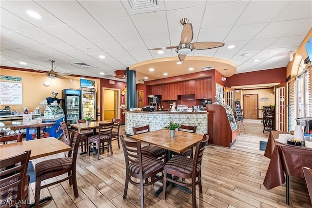 dining area with visible vents, light wood-type flooring, and a ceiling fan