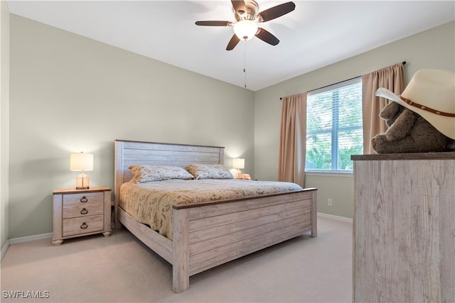 bedroom with light carpet, ceiling fan, and baseboards