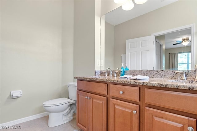 bathroom with toilet, double vanity, a sink, and tile patterned floors