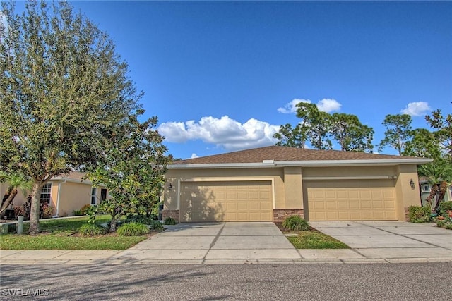 view of front of house featuring a garage, brick siding, driveway, and stucco siding