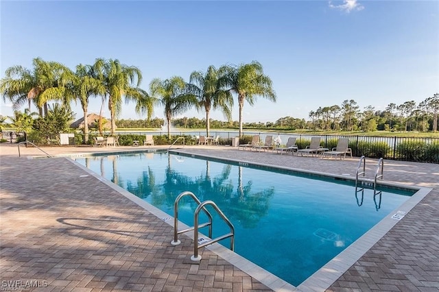 community pool with a patio area and fence