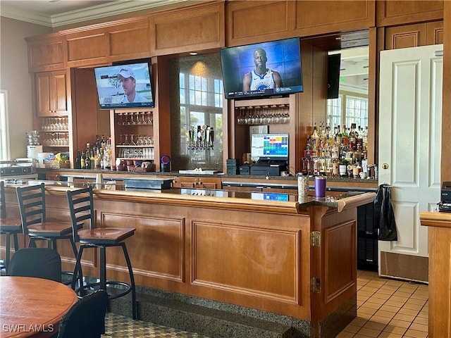 bar with ornamental molding, a dry bar, and light tile patterned floors