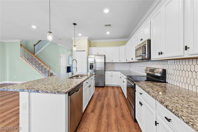 kitchen featuring visible vents, stainless steel appliances, crown molding, light wood-style floors, and a sink