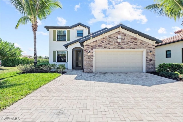 view of front of home featuring stone siding, an attached garage, decorative driveway, a front lawn, and stucco siding