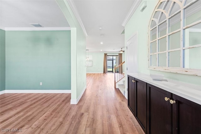 bar with light wood finished floors, visible vents, ornamental molding, baseboards, and stairs