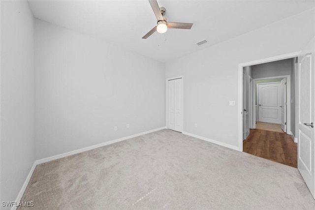 unfurnished bedroom featuring baseboards, visible vents, a ceiling fan, carpet flooring, and a closet