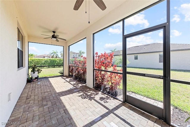 unfurnished sunroom with ceiling fan