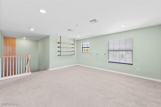 unfurnished room with carpet floors, baseboards, visible vents, and recessed lighting