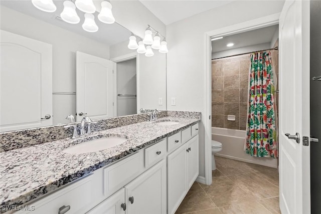 bathroom with double vanity, toilet, a sink, and tile patterned floors