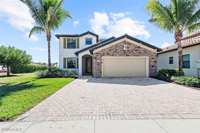 view of front of home featuring a front yard, decorative driveway, an attached garage, and stucco siding