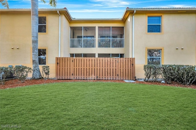 exterior space featuring a lawn, fence, and stucco siding