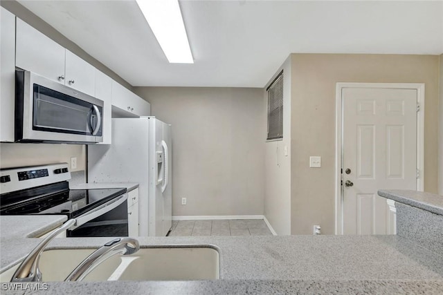 4109 Bellasol Cir Unit 1113, Fort Myers, FL 33916 - kitchen with light tile patterned floors, stainless steel appliances, white cabinets, a sink, and baseboards