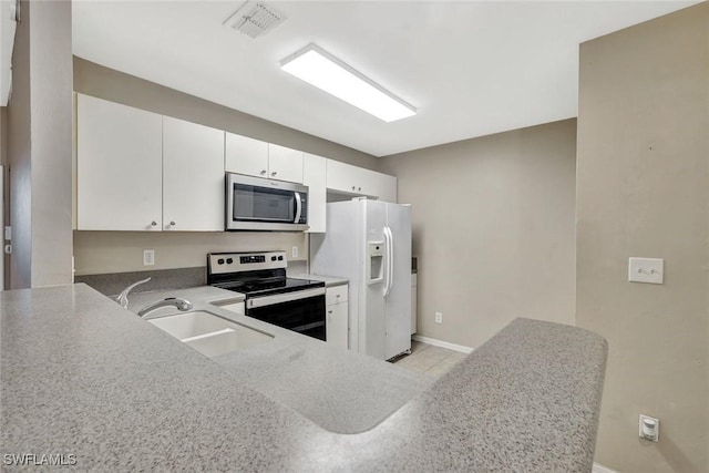 4109 Bellasol Cir Unit 1113, Fort Myers, FL 33916 - kitchen with visible vents, a peninsula, stainless steel appliances, white cabinetry, and a sink