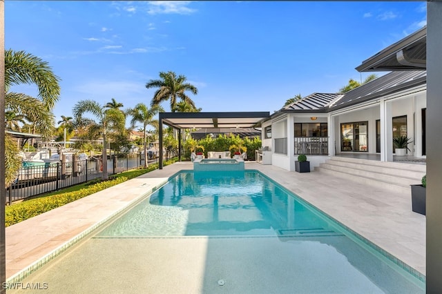 view of swimming pool featuring a pool with connected hot tub, a patio, and fence