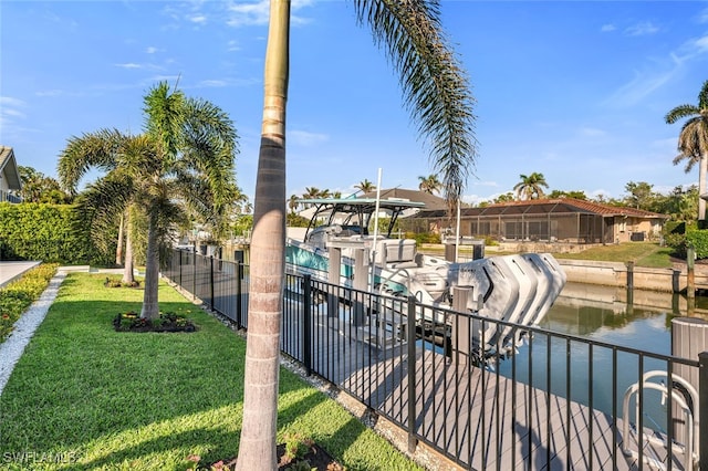 view of property's community with a water view, a lawn, a boat dock, and fence