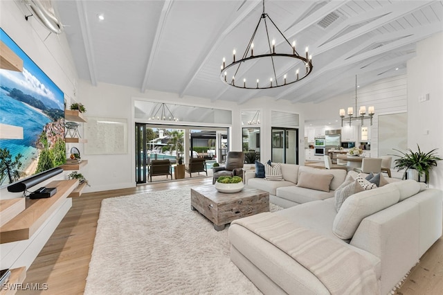 living area with a chandelier, light wood-type flooring, visible vents, and beamed ceiling