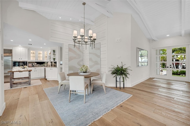 dining space with high vaulted ceiling, beamed ceiling, light wood-style flooring, and an inviting chandelier