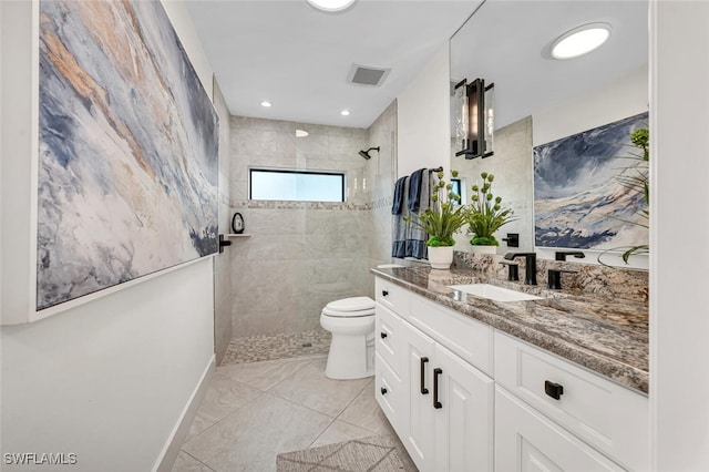 bathroom featuring baseboards, visible vents, toilet, vanity, and a walk in shower