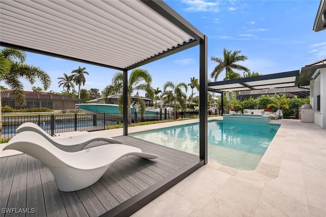 view of pool with a patio area, fence, and a pool with connected hot tub