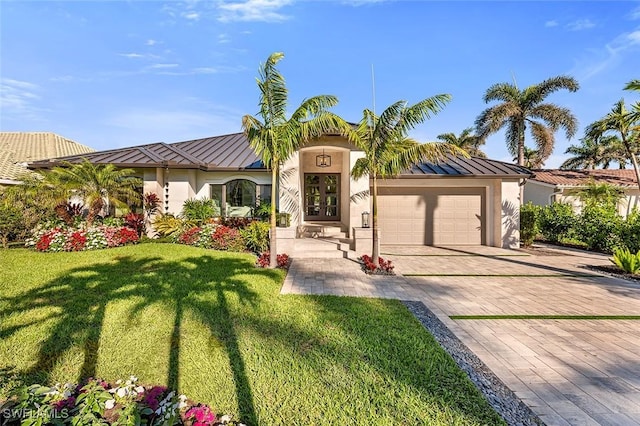 mediterranean / spanish-style home featuring metal roof, an attached garage, decorative driveway, stucco siding, and a standing seam roof