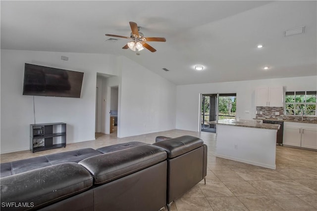 living area with lofted ceiling, a wealth of natural light, and visible vents