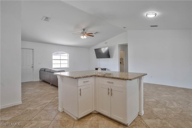 kitchen featuring visible vents, a kitchen island, white cabinetry, and open floor plan