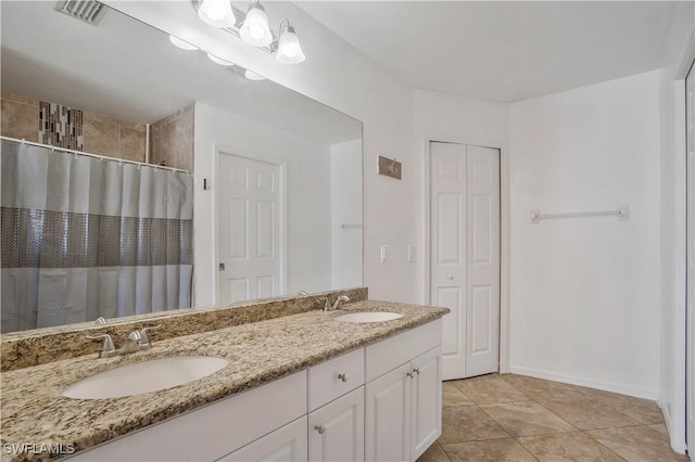 bathroom with a closet, visible vents, a sink, and double vanity