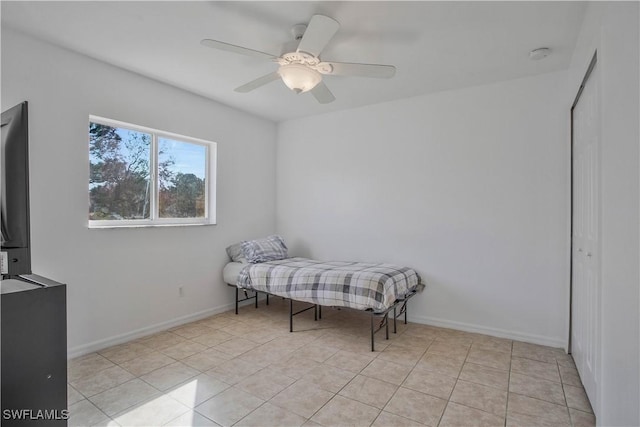 bedroom featuring a ceiling fan, baseboards, and light tile patterned floors