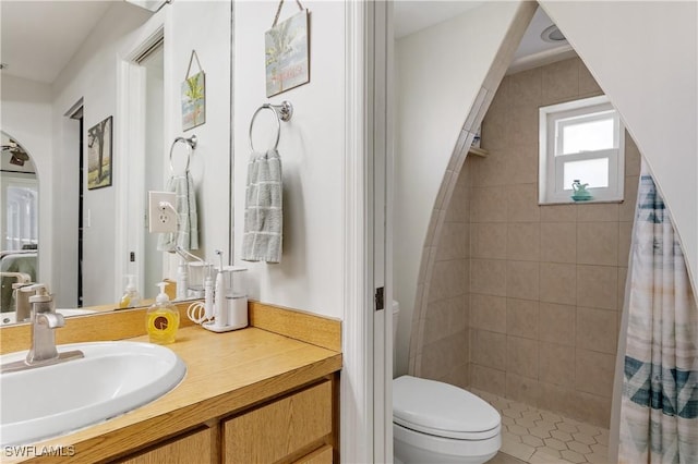 bathroom featuring toilet, a stall shower, and vanity