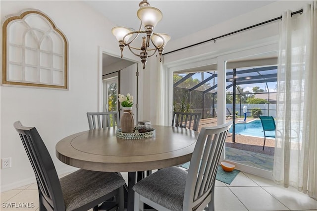 dining space featuring light tile patterned floors, a sunroom, and an inviting chandelier