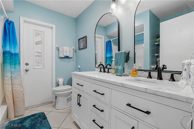 bathroom featuring tile patterned flooring, a sink, toilet, and double vanity