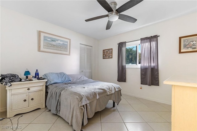 bedroom featuring a ceiling fan, baseboards, and light tile patterned floors