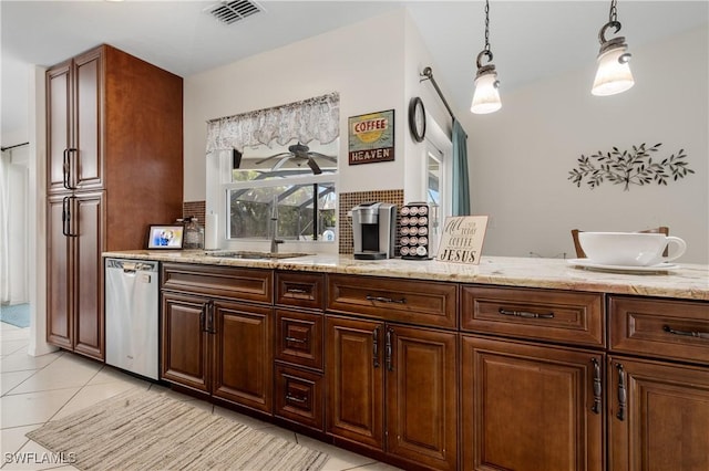 kitchen with light tile patterned floors, light stone counters, visible vents, dishwasher, and pendant lighting