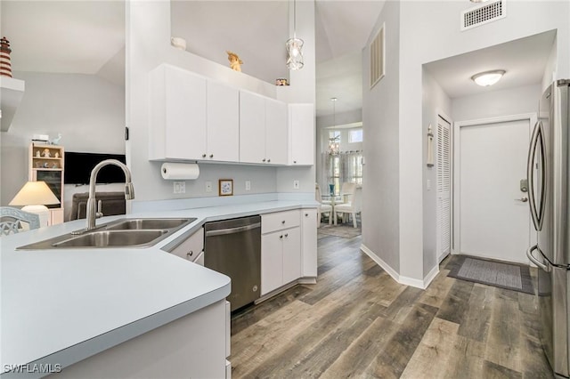 kitchen featuring white cabinetry, appliances with stainless steel finishes, pendant lighting, and light countertops