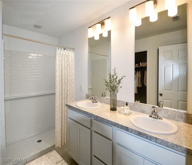 bathroom featuring a walk in closet, visible vents, a sink, and a shower with curtain