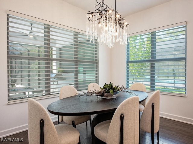 dining area featuring dark wood-style flooring, an inviting chandelier, and baseboards