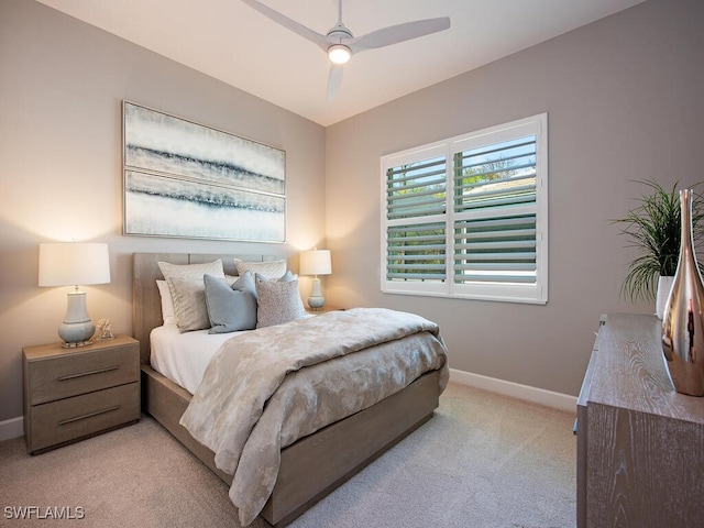 bedroom featuring light carpet, ceiling fan, and baseboards