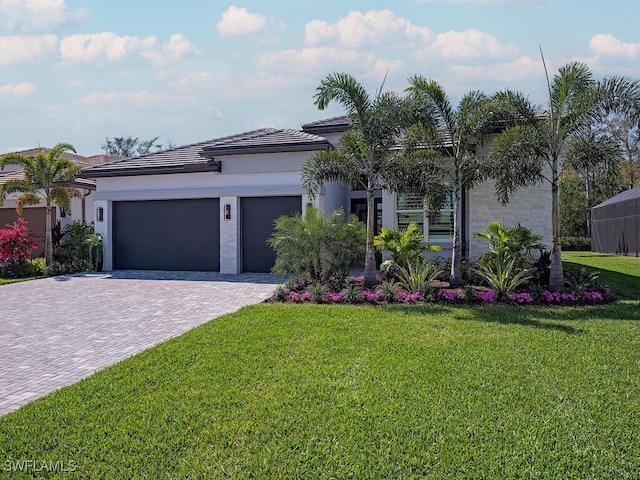 view of front of property featuring a garage, a front lawn, decorative driveway, and stucco siding