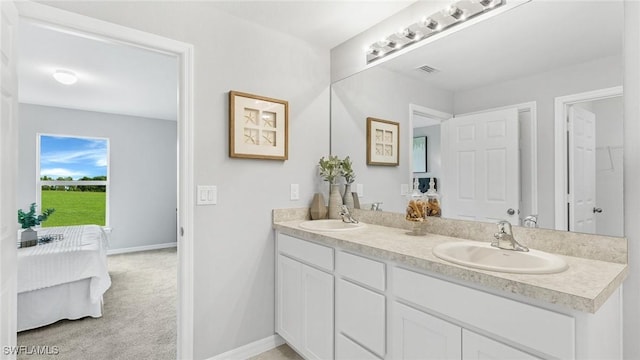 bathroom with a sink, double vanity, visible vents, and connected bathroom