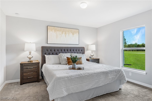 bedroom featuring light carpet and baseboards