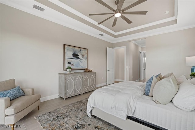 bedroom with a tray ceiling, visible vents, and ornamental molding