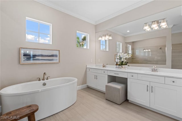 bathroom with baseboards, a freestanding tub, a sink, walk in shower, and crown molding