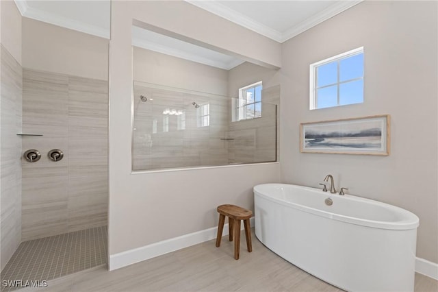 bathroom with baseboards, a soaking tub, crown molding, and a walk in shower