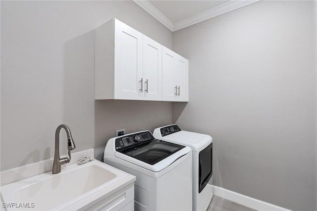 laundry area with baseboards, cabinet space, ornamental molding, a sink, and independent washer and dryer