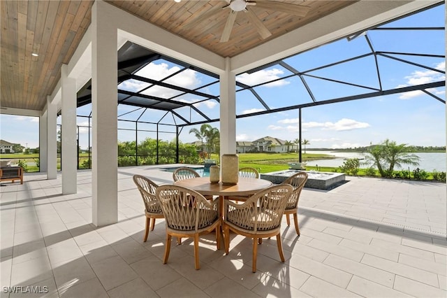 view of patio / terrace with ceiling fan, a water view, an outdoor fire pit, glass enclosure, and an outdoor pool